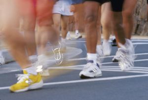 Blurred action image of runners feet during race, reflective shoes