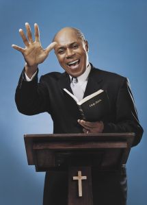 Man Stands at a Podium Preaching From a Bible With One Arm Raised