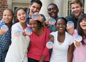 Students holding buttons at voter registration