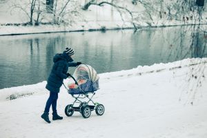 Woman with a baby stroller on a walk in the park