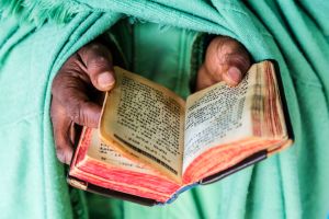 Close up of hands of priest holding Bible