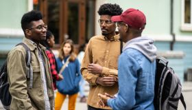 African-American students having a conversation outdoors in from of the University