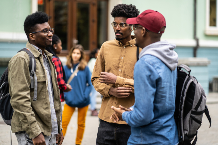 African-American students having a conversation outdoors in from of the University