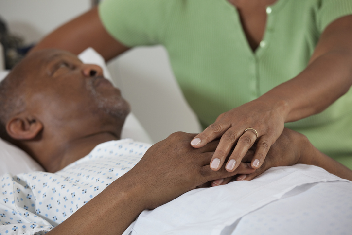 Black wife comforting husband in hospital
