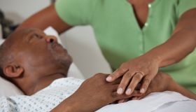 Black wife comforting husband in hospital