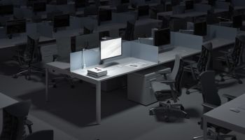 Illuminated computer on desk in darkroom at office