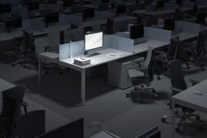 Illuminated computer on desk in darkroom at office