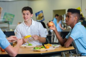 Teenage boys eat lunch in school cafeteria