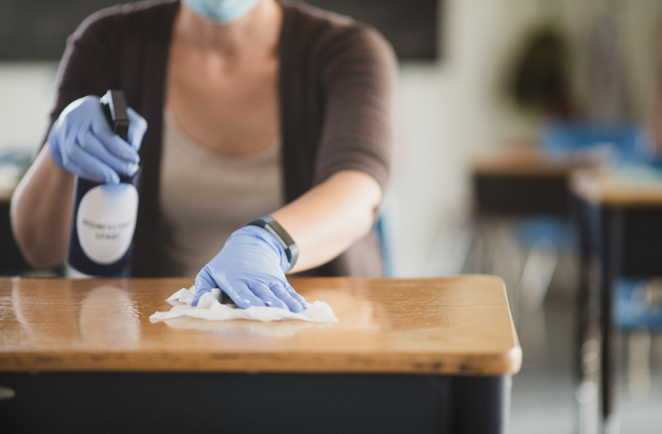 Teacher disinfecting the classroom