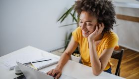 Multiracial woman listening to online course at home