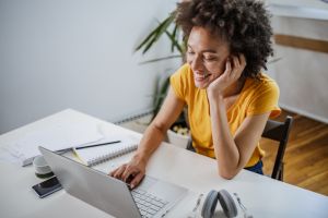 Multiracial woman listening to online course at home