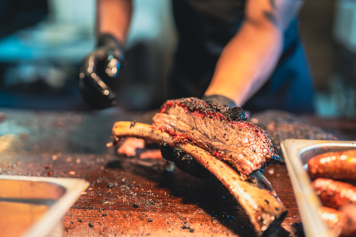BBQ Chef Displays a delicious Smoked Brisket that's Falling Right Off the Bone.