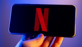 In this photo illustration, a Netflix logo seen displayed on...