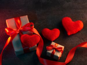 Gifts for Valentine 's Day . Red Knitted Heart and Wrapped Gift Boxes with Red Ribbon top view
