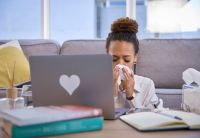 Blowing nose, sick and laptop with black woman in living room for fever, remote worker and freelancer. Illness, flu and sneeze with girl suffering at home for virus, headache and healthcare problem