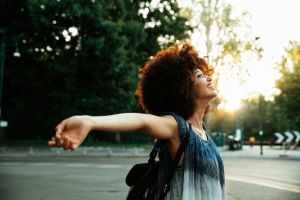 Happy woman with arms outstretched breathing fresh hair