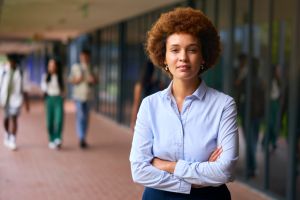 Portrait Of Female High School Or Secondary School Teacher Outdoors At School