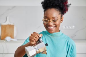 Cute girl in the kitchen, making a coffee