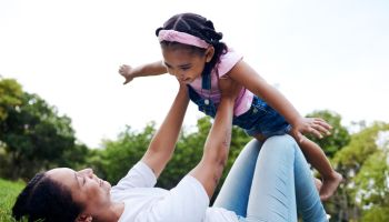 Black family, park and flying with a woman and girl having fun together while bonding on grass outdoor. Kids, love and nature with a mother and daughter playing in a green garden outside in summer