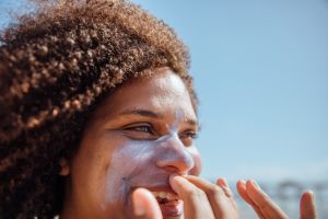 Woman applying sunscreen on the beach