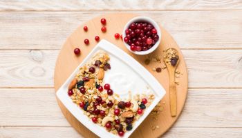 Healthy breakfast food with granola, yogurt, fruits and nuts. Dessert parfait with dried fruits for breakfast