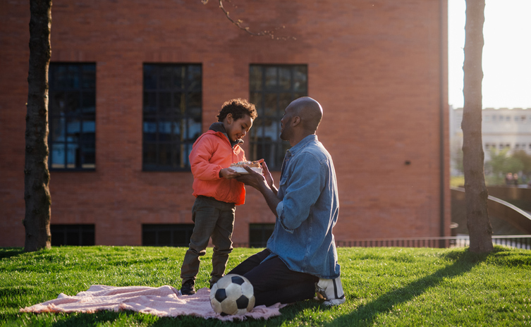 Single father playing football with his little son.