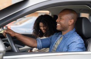 Happy couple going on a road trip in their car