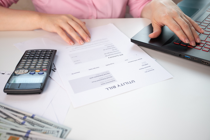Utility bill, Invoice for energy consumption, electricity and gas receipt, a woman behind a worker considers the budget for utilities,