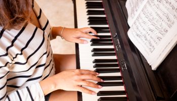 Woman's hands are playing the piano, she plays music to relax and relieve stress with music. See close-up photos of the musicians. Hobby concept