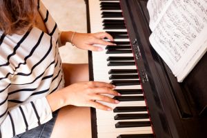 Woman's hands are playing the piano, she plays music to relax and relieve stress with music. See close-up photos of the musicians. Hobby concept