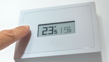 Lowering the temperature of a home thermostat due to energy crisis.