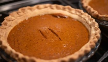 Perfect homemade pumpkin pie with rustic crust hand crimped edges and two test cut marks.