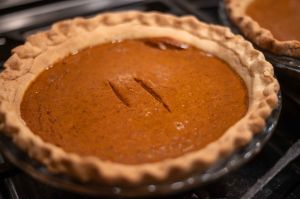 Perfect homemade pumpkin pie with rustic crust hand crimped edges and two test cut marks.