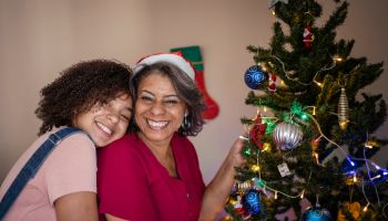 Mother and daughter decorating the Christmas tree at home