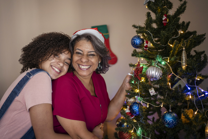 Mother and daughter decorating the Christmas tree at home