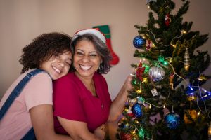 Mother and daughter decorating the Christmas tree at home
