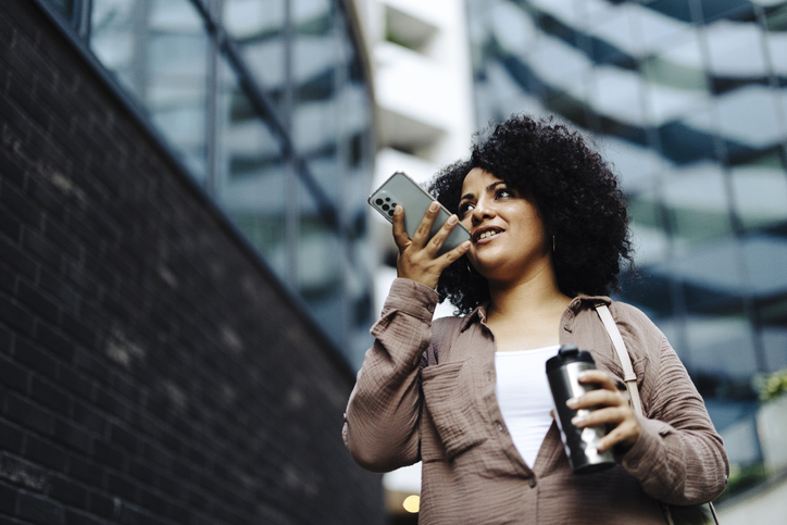 Woman holding smartphone near mouth using speakerphone, send audio voice message to friend, using virtual assistant, talking through loudspeaker easy advanced usage of modern tech concept
