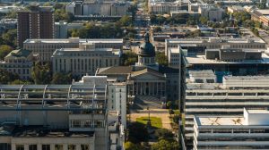 Government building stands on Main Street amidst office buildings in Columbia, SC. South Carolina State House rise above the Downtown District. Aerial view