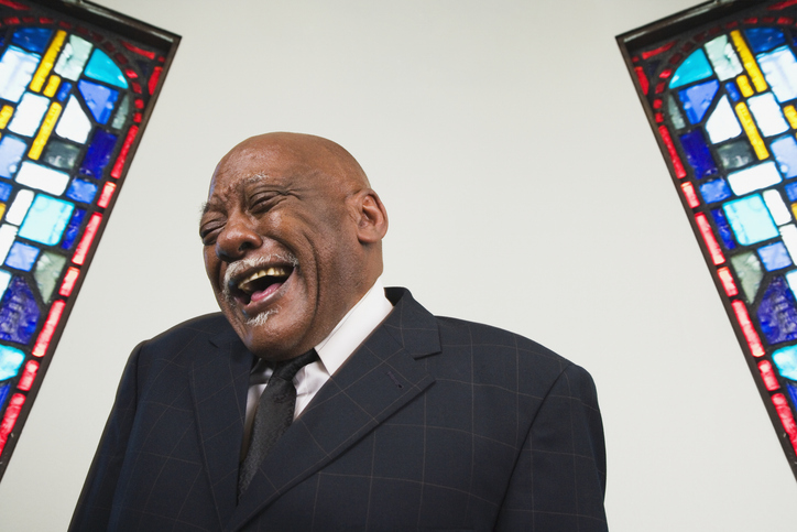 Senior African man laughing in church