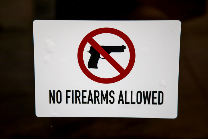 Sign stating No Firearms allowed with red circle and red line
