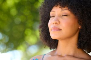 Woman Outdoors Relaxing In Countryside Closing Eyes And Breathing Deeply Enjoying Calm Of Nature