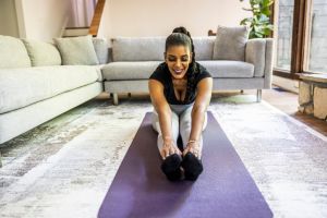 Senior woman practicing yoga in living room