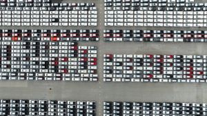 aerial top down view of a parking lot new cars lined up in the port for import and export international.