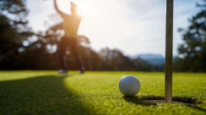 Blurred golfer playing golf in the evening golf course, on sun set evening time.