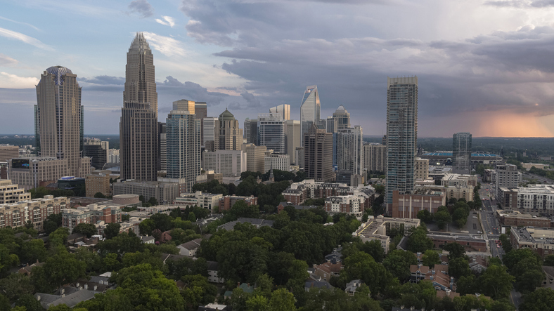 Downtown Charlotte, NC, with luxury apartments against the stormy sky at sunset.