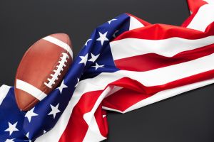 American football ball and american flag on table close up