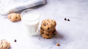 Chocolate chip cookies with a glass of milk on a marble background