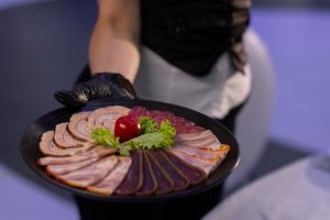 Waiter holding a platter of assorted deli meats