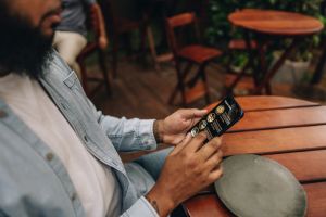 Close-up of a man looking at menu on mobile phone at restaurant