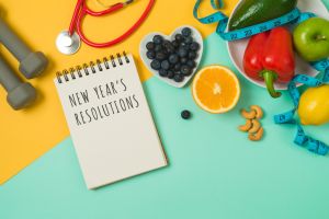 New Year resolutions concept. Healthy lifestyle and balanced diet vegetables, fruits, medical stethoscope, dumbbells and notebook